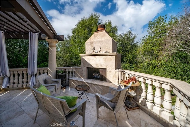 view of patio / terrace featuring exterior fireplace