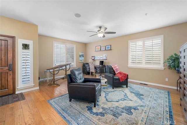 sitting room featuring visible vents, light wood-style flooring, baseboards, and ceiling fan