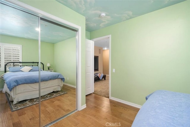 bedroom featuring a closet, baseboards, and wood finished floors