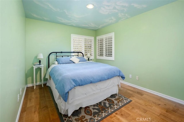 bedroom featuring baseboards and wood finished floors