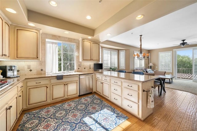 kitchen with tasteful backsplash, open floor plan, dishwasher, light wood-style flooring, and a peninsula