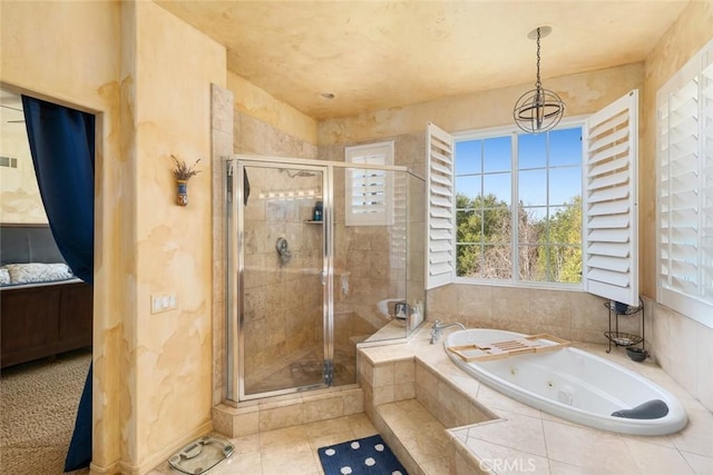 bathroom featuring an inviting chandelier, a shower stall, a jetted tub, and visible vents