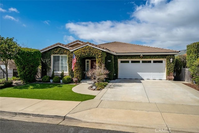 ranch-style house featuring a front yard, fence, concrete driveway, a garage, and a tiled roof