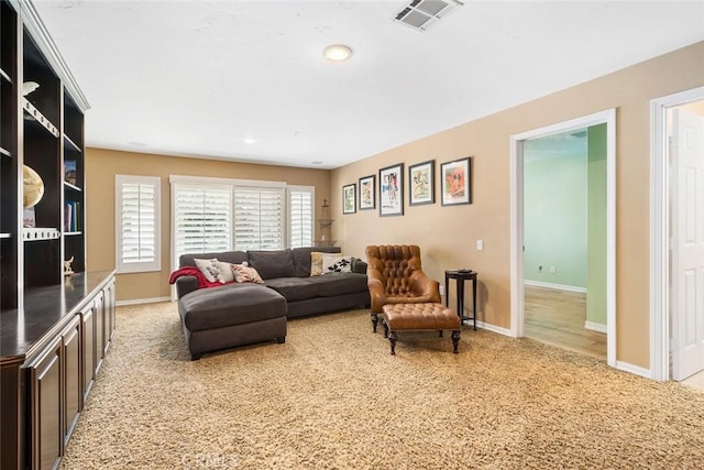 living area featuring recessed lighting, visible vents, baseboards, and carpet