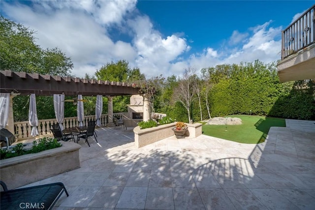 view of patio / terrace featuring a balcony and an outdoor fireplace