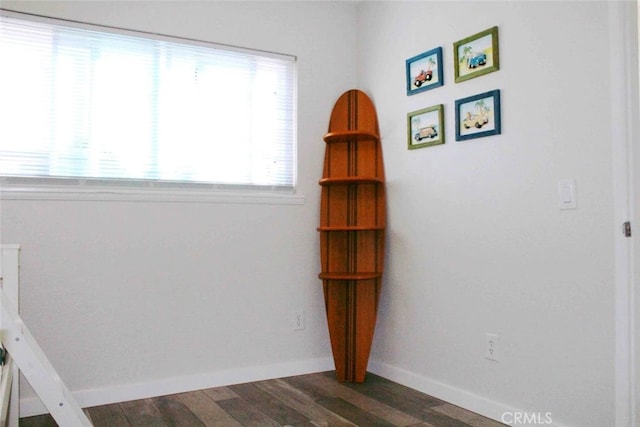 interior space featuring baseboards and dark wood-style flooring