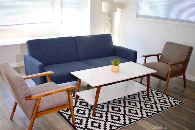 living area with baseboards and wood finished floors