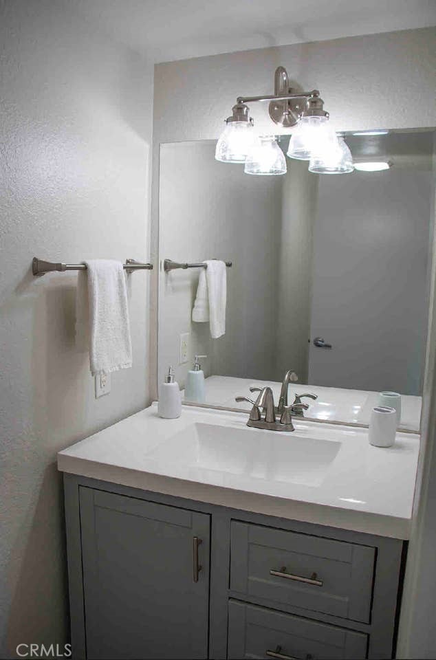 bathroom featuring vanity and a textured wall