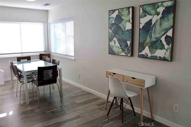 dining room featuring visible vents, baseboards, and wood finished floors