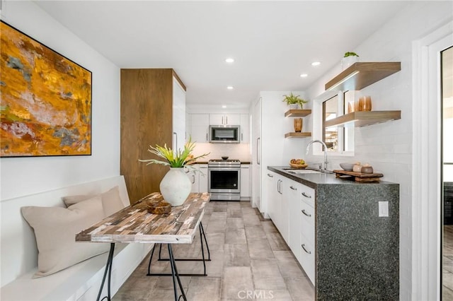 426 Monarch Bay Dr, Dana Point, CA 92629 - kitchen with a sink, open shelves, white cabinetry, appliances with stainless steel finishes, and dark countertops