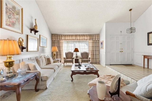 living area featuring a decorative wall, carpet, a wainscoted wall, and a textured ceiling