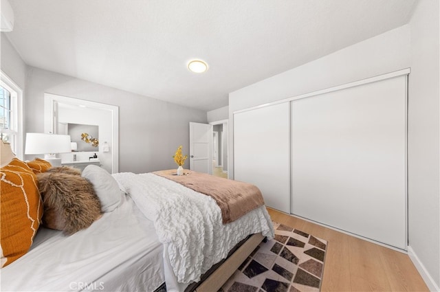 bedroom with a closet and light wood finished floors