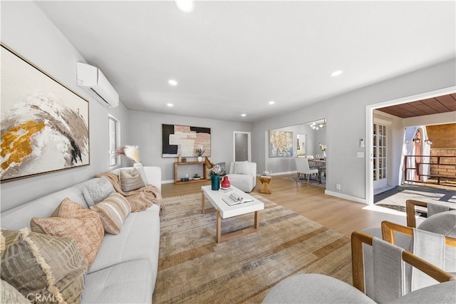 living area with recessed lighting, baseboards, light wood-style floors, and an AC wall unit