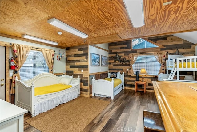 bedroom with wooden walls, wood ceiling, and wood finished floors