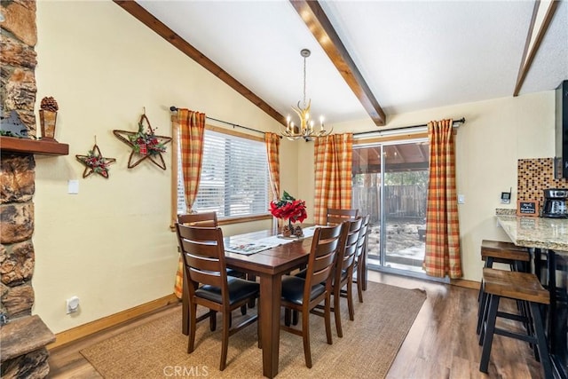 dining area featuring a chandelier, vaulted ceiling with beams, baseboards, and wood finished floors