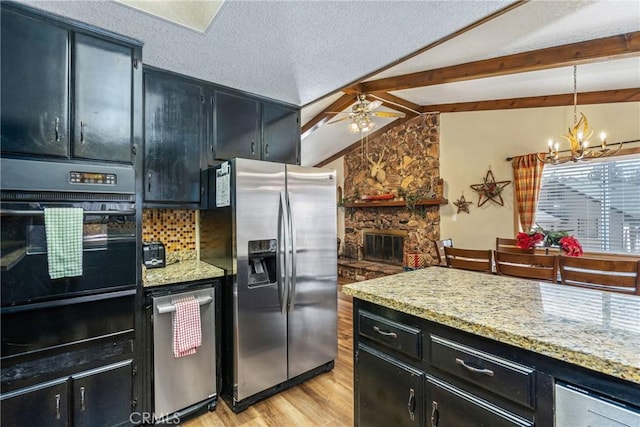 kitchen with light wood-style flooring, vaulted ceiling with beams, dark cabinets, and appliances with stainless steel finishes