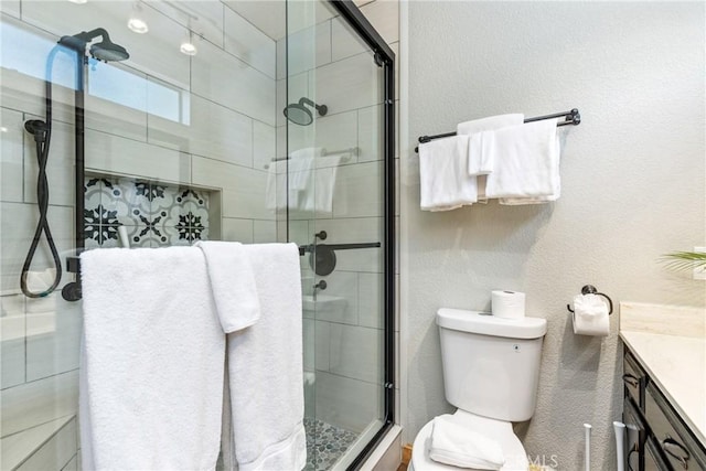 full bathroom with a shower stall, toilet, vanity, and a textured wall