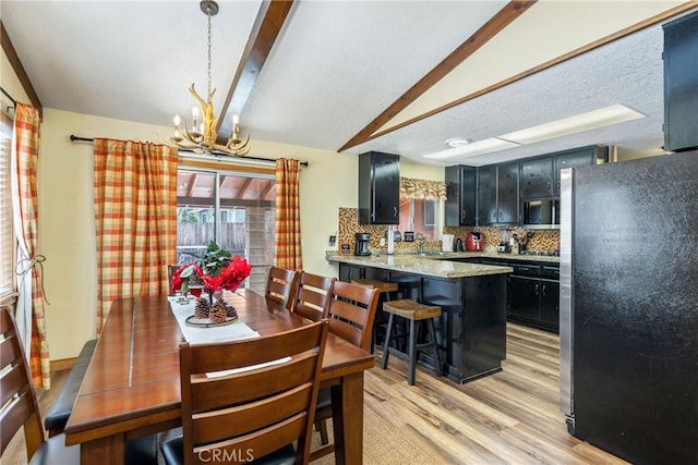 dining space featuring an inviting chandelier, lofted ceiling, and light wood-type flooring