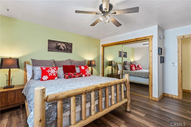 bedroom featuring a closet, a textured ceiling, baseboards, and wood finished floors