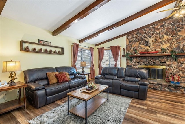 living room featuring a fireplace, vaulted ceiling with beams, wood finished floors, and a ceiling fan