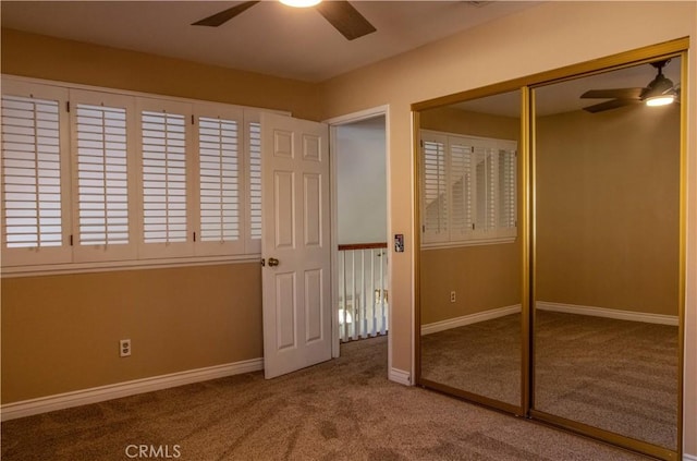 unfurnished bedroom featuring a closet, ceiling fan, baseboards, and carpet floors