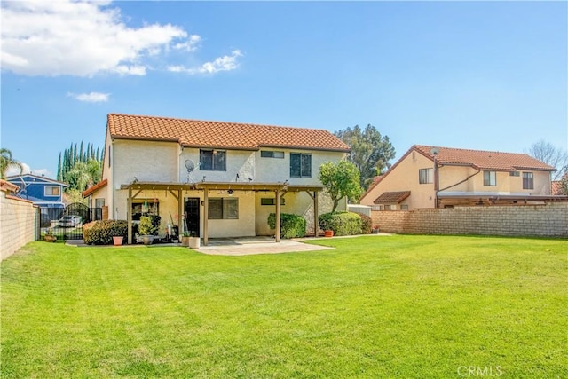 rear view of property featuring a patio, a fenced backyard, stucco siding, a tiled roof, and a lawn