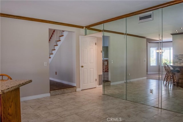 empty room with crown molding, stairway, baseboards, and visible vents