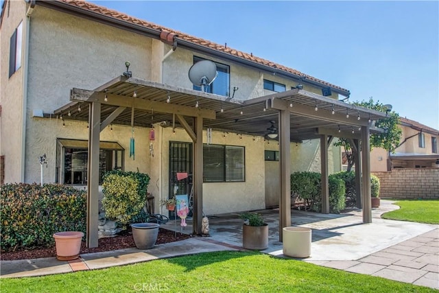 back of house featuring stucco siding, a tile roof, a patio, fence, and ceiling fan