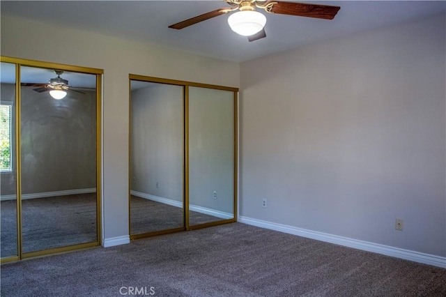 unfurnished bedroom featuring baseboards, two closets, ceiling fan, and carpet