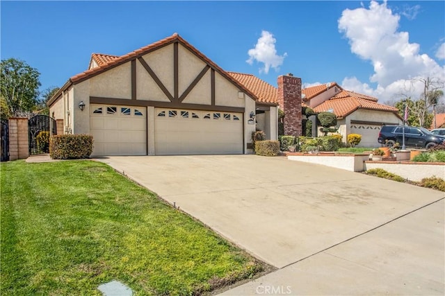 tudor home featuring a tile roof, concrete driveway, stucco siding, a garage, and a gate