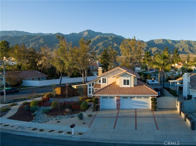 view of front of home with a gate, fence, and a mountain view