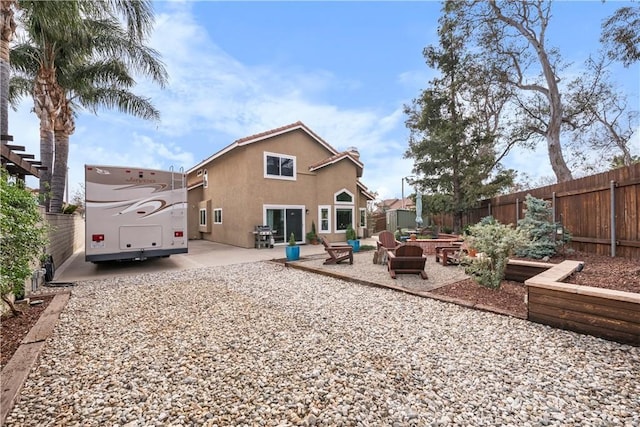 rear view of house with a patio area, a fenced backyard, and stucco siding