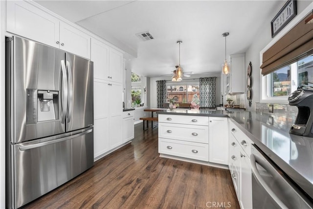 kitchen with visible vents, a peninsula, stainless steel appliances, dark wood-type flooring, and white cabinetry