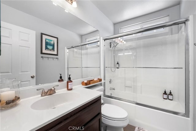 bathroom with shower / bath combination with glass door, toilet, and vanity