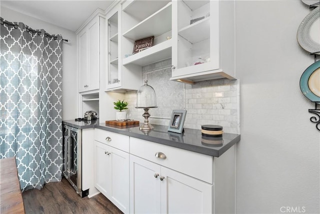 kitchen with beverage cooler, tasteful backsplash, dark countertops, glass insert cabinets, and dark wood-style flooring