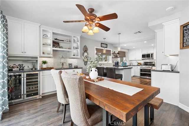 dining room with beverage cooler, visible vents, a ceiling fan, dark wood finished floors, and recessed lighting