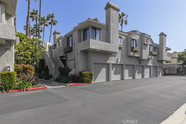 view of building exterior with a garage and a residential view