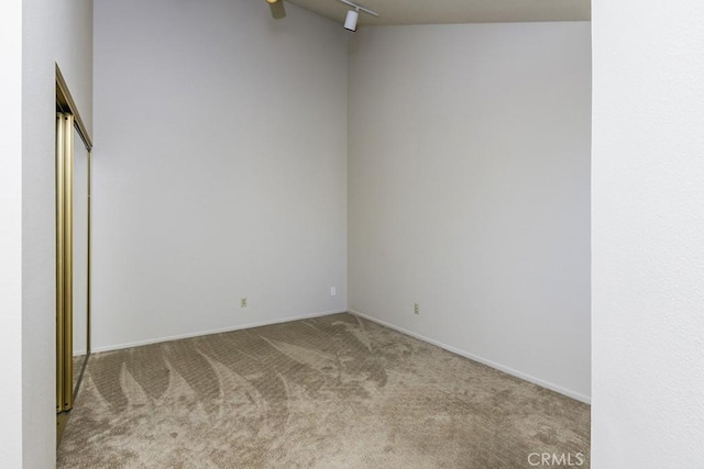 carpeted spare room featuring track lighting