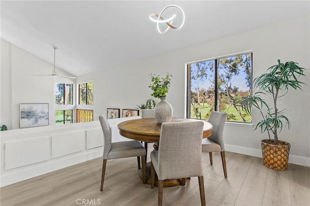 dining space featuring vaulted ceiling, light wood-style flooring, baseboards, and a chandelier