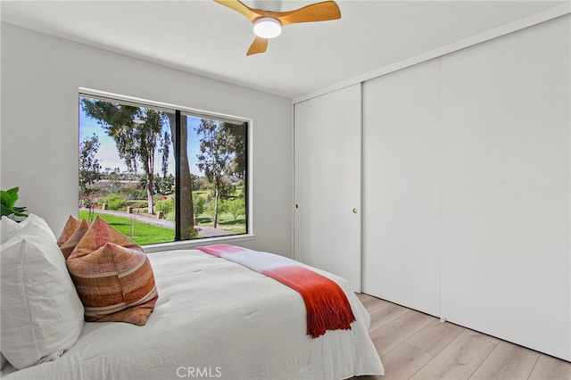 bedroom with a closet, wood finished floors, and a ceiling fan