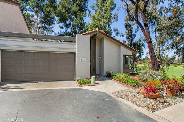 view of front of home featuring stucco siding, driveway, and a tiled roof