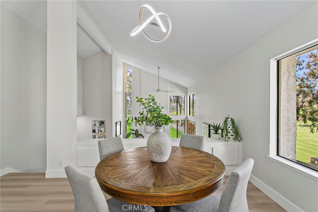 dining room with lofted ceiling, light wood-style floors, and baseboards