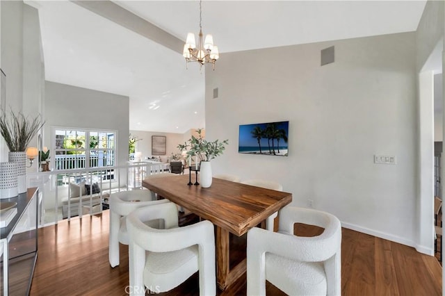 dining area with baseboards, wood finished floors, a chandelier, and a towering ceiling