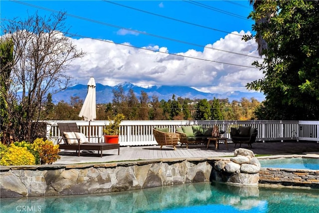 view of swimming pool featuring an in ground hot tub and a deck with mountain view