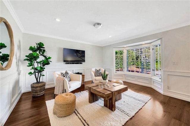 living room with dark wood finished floors, a decorative wall, and ornamental molding