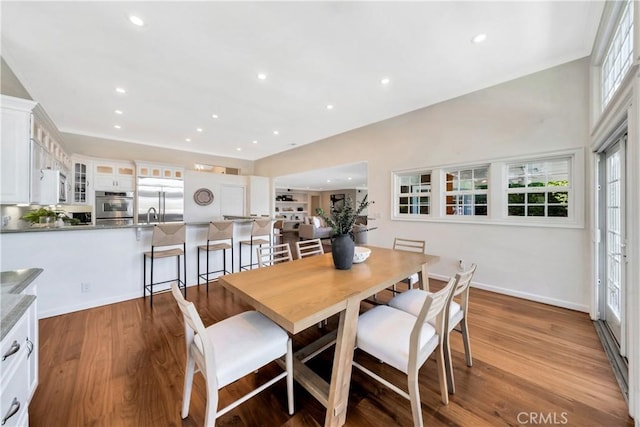 dining room with a wealth of natural light, recessed lighting, and wood finished floors