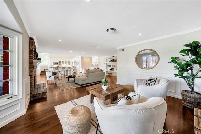 living area with dark wood-type flooring, a decorative wall, a fireplace, and ornamental molding