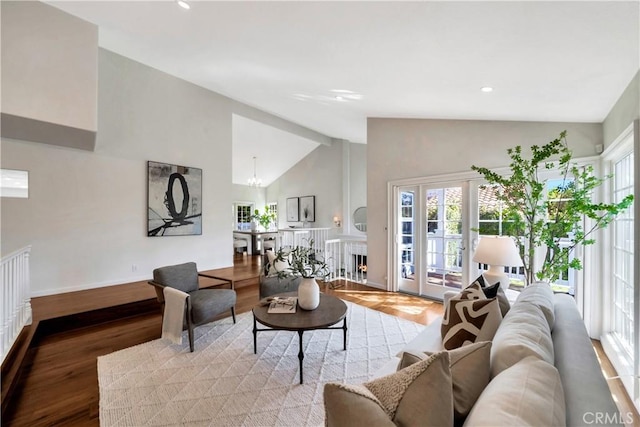 living area with baseboards, recessed lighting, a warm lit fireplace, a notable chandelier, and parquet floors