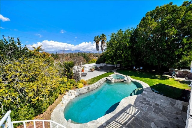 view of pool featuring a patio area, a yard, a pool with connected hot tub, and a fenced backyard