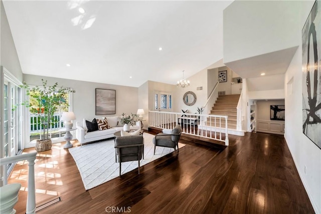 living room featuring wood finished floors, high vaulted ceiling, an inviting chandelier, recessed lighting, and stairs